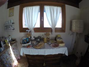 a table with food on it in a kitchen with a window at B&B Maison La Coccola in Peschiera del Garda