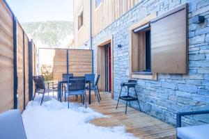 a balcony with a table and chairs on a brick building at PORTES DU PLENEY 001 in Morzine