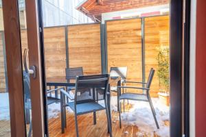 a patio with a table and chairs and a fence at PORTES DU PLENEY 001 in Morzine