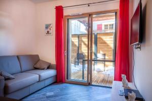 uma sala de estar com um sofá e uma porta de vidro deslizante em PORTES DU PLENEY 001 em Morzine