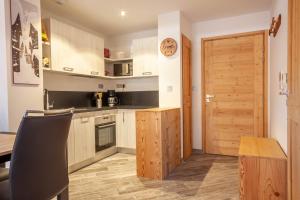 uma cozinha com armários de madeira e uma porta de madeira em PORTES DU PLENEY 001 em Morzine