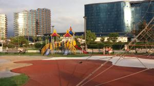 a playground in a park with buildings in the background at Бежевые апартаменты in Batumi