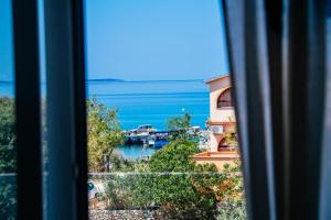 een raam met uitzicht op de oceaan bij Boutique Villa Nirvana 2, Proboj 25 in Pag