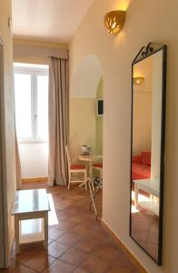 a living room with a mirror and a table at B&B Il Porticciolo di Amalfi in Amalfi