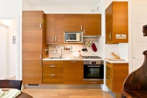 a kitchen with wooden cabinets and a microwave at Flat in the heart of Pisa in Pisa