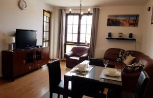 Una sala de estar con una mesa y un televisor. en Apartments Bulwar Portowy, en Ustka