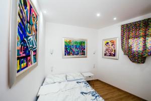 een slaapkamer met schilderijen aan de muren en een bed bij Boutique Villa Nirvana 2, Proboj 25 in Pag