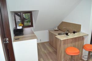 RELU في متسختا: مطبخ صغير مع حوض و كراسي برتقالية