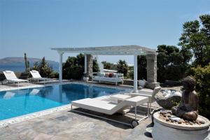 una piscina con una estatua junto a un sofá y una dolencia en Quality Brand Villas Sea & Sun Villa A SUPERB LUXURY EXCLUSIVE VILLA WITH PERSONALITY en Kalafatis