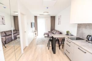 a kitchen and living room with a table and chairs at Apartments Family - Vėsa in Palanga