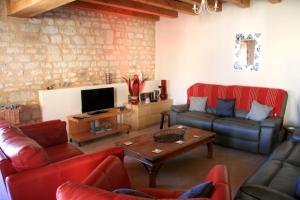 a living room with red couches and a tv at Loire Escapes in Berrie