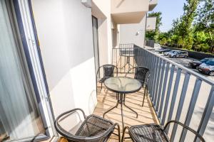 a balcony with chairs and a table on a building at Apartments Family - Vėsa in Palanga