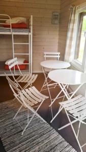 a room with two tables and chairs and a bed at Koljonvirta Camping in Iisalmi