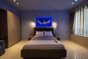 a bedroom with a large bed with a blue painting on the wall at Angel Deluxe Apartments & Suites Thessaloniki in Thessaloniki