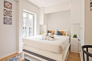 a bedroom with a large white bed with two teddy bears on it at BmyGuest Bruno’s 36 Apartments in Lisbon