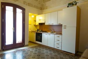 a kitchen with white cabinets and a sink and a window at Cà di Rò in Polignano a Mare