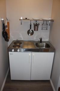 a small kitchen with a sink and a stove at Studioleilighet i Haukedalen in Holsen