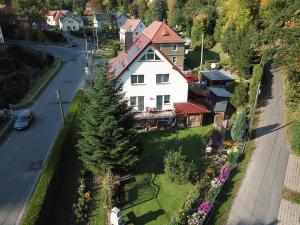 a white house with a red roof and a street at Ferienwohnung Richter in Tharandt +3 photos