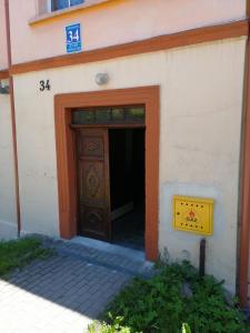 a building with a large wooden door with a sign above it at Topsen Jedlina-Zdrój in Jedlina-Zdrój