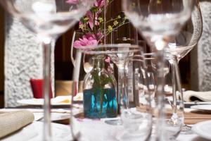 una mesa con copas de vino y una botella con flores. en Casona De Torres, en Mondéjar