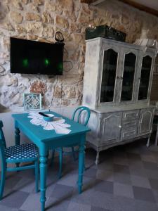 a blue table and chairs in a room with a tv at Apartments Miki in Komiža