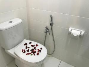 a bathroom with a toilet with pomegranates on the lid at CozyStudio Trefoil Setia Alam in Shah Alam