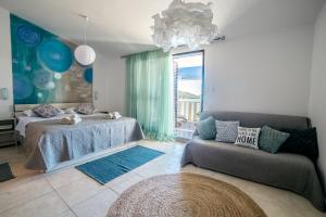 a bedroom with a bed and a couch and a window at Apartments Horizont in Rogoznica