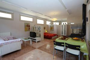 a living room with a couch a table and a bed at Finca Sa Tafona in Son Servera