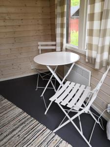 a table and two chairs sitting next to a window at Koljonvirta Camping in Iisalmi