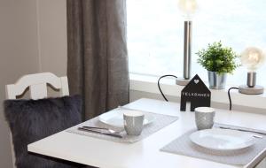 a white table with two plates and cups on it at Studioleilighet i Haukedalen in Holsen