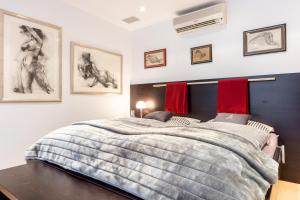 a bedroom with a large bed and paintings on the wall at James Home in Kampen