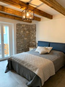 una camera da letto con un grande letto e un muro in pietra di Casa La Margherita a Desenzano del Garda