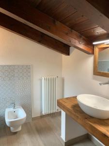 bagno con lavandino, servizi igienici e specchio di Casa La Margherita a Desenzano del Garda