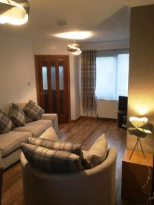 a living room with a couch and a table at Kennedy Terrace; Modern 2 bedroom house, central in Stornoway