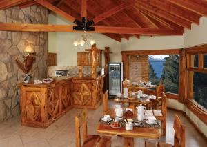 a kitchen with wooden cabinets and tables in a room at Apart Altos Del Nahuel in San Carlos de Bariloche