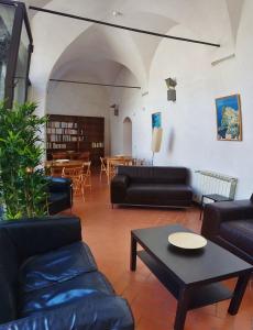 a living room with black furniture and a table at Ospitalia del Mare Hostel in Levanto