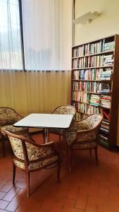a table and two chairs and a book shelf with books at Ospitalia del Mare Hostel in Levanto
