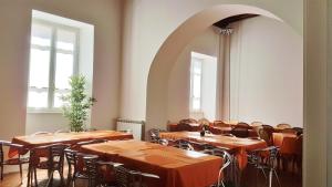 a dining room with tables and chairs and windows at Ospitalia del Mare Hostel in Levanto