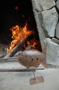 a wooden fish is standing in front of a fire at Aguas Arriba Lodge in El Chalten