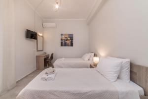ein Hotelzimmer mit zwei Betten und einem Fernseher in der Unterkunft Sea La Vie Villa in Zakynthos