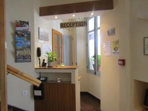 une salle de réception avec un panneau indiquant la réception dans l'établissement Fifi Moulin, à Serres