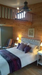 duże łóżko w pokoju z drewnianymi ścianami w obiekcie Nire Valley Eco Camp w mieście Ballymacarbry