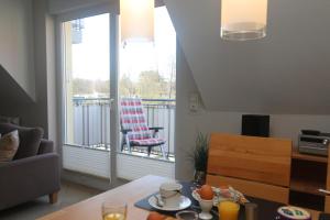 a living room with a table and a balcony at Ferienwohnung Strandaster in Zingst
