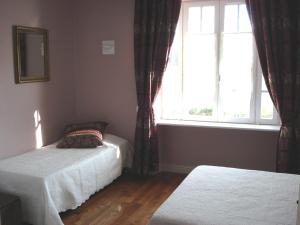 um quarto com 2 camas e uma janela em Maison d'hôtes La Tuilerie em Peschadoires