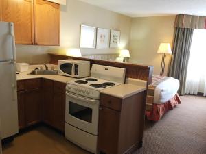 a hotel room with a kitchen with a stove and a bed at Charlottetown Inn & Conference Centre in Charlottetown
