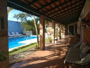 a patio with a swimming pool and a house at Pousada Chateau Sophie in Itanhaém