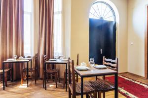 un comedor con mesas y sillas y una puerta azul en Memory House en Kutaisi