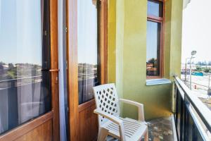 een witte stoel op een balkon naast een raam bij Memory House in Koetaisi