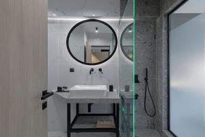 a bathroom with a sink and a mirror at Philosofia Athens Suites in Athens