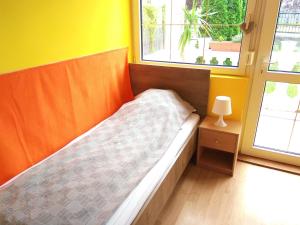 a bed in a room with two windows at Koppi Ház in Siófok